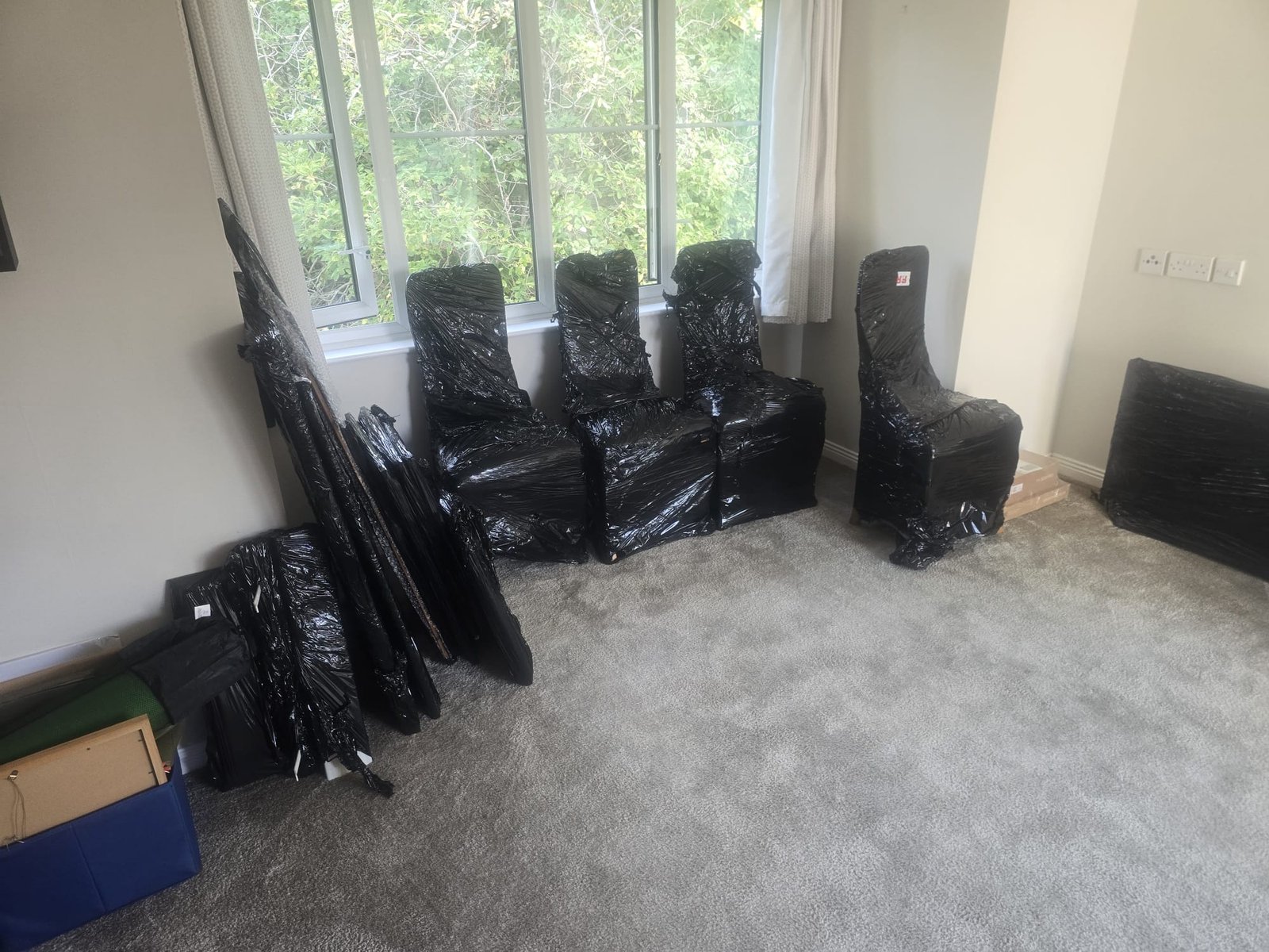 Dining chairs wrapped in protective film after delivery on a Kingston house move