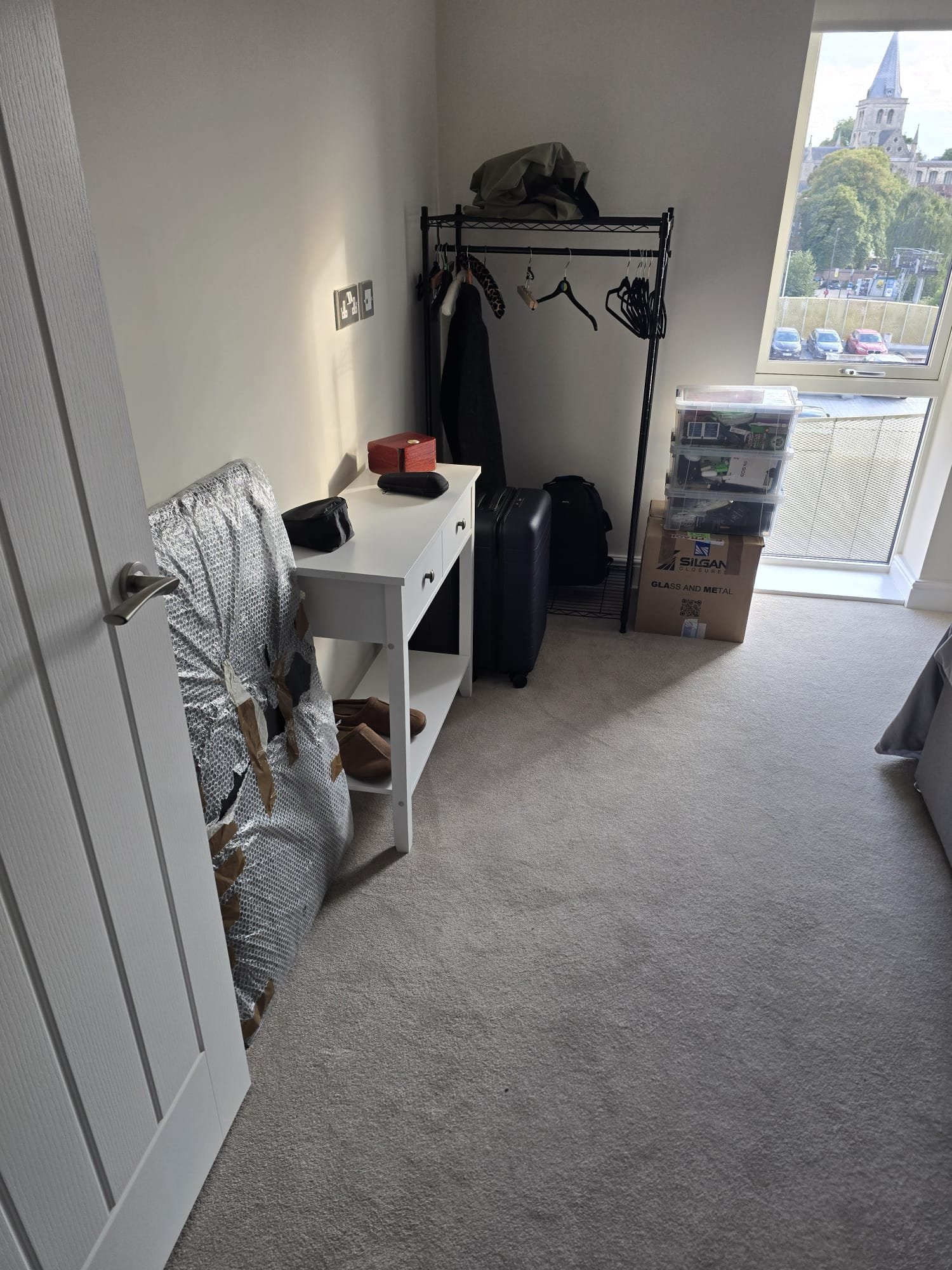 Room set up with clothes rail, dressing table and suitcases unloaded