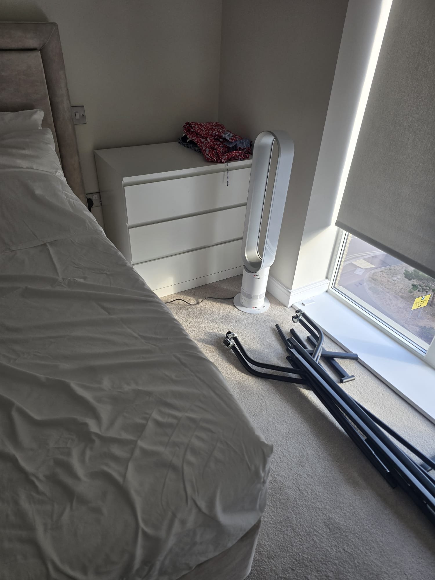 Bedroom in the new flat with the bed being rebuilt next to the chest of drawers